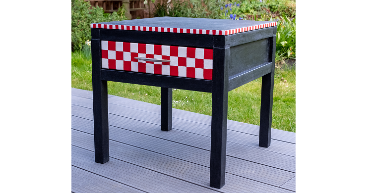 unique red and white square painted side table with a black base