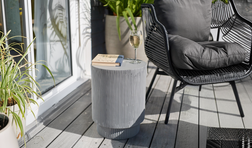 Planted pots and a compact side table beside outdoor seating
