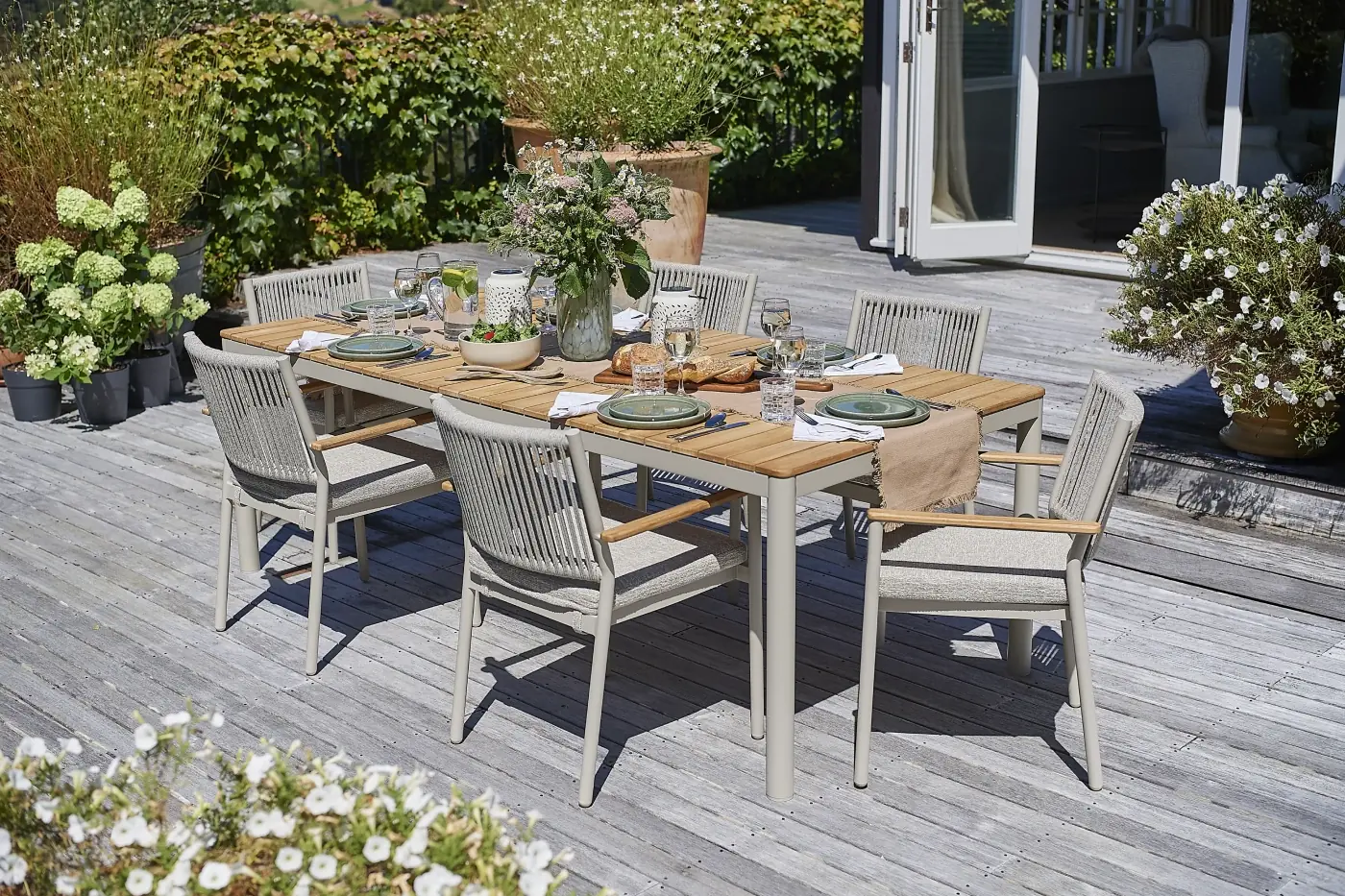 Sicily outdoor dining setting with an umbrella, cushions and tableware
