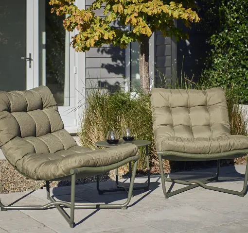 Two wicker lounge chairs and a side table on a timber deck